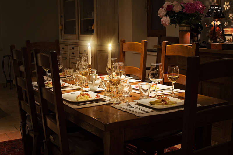 Ein schön gedeckter Tisch mit Kerzenlicht iluminiert.